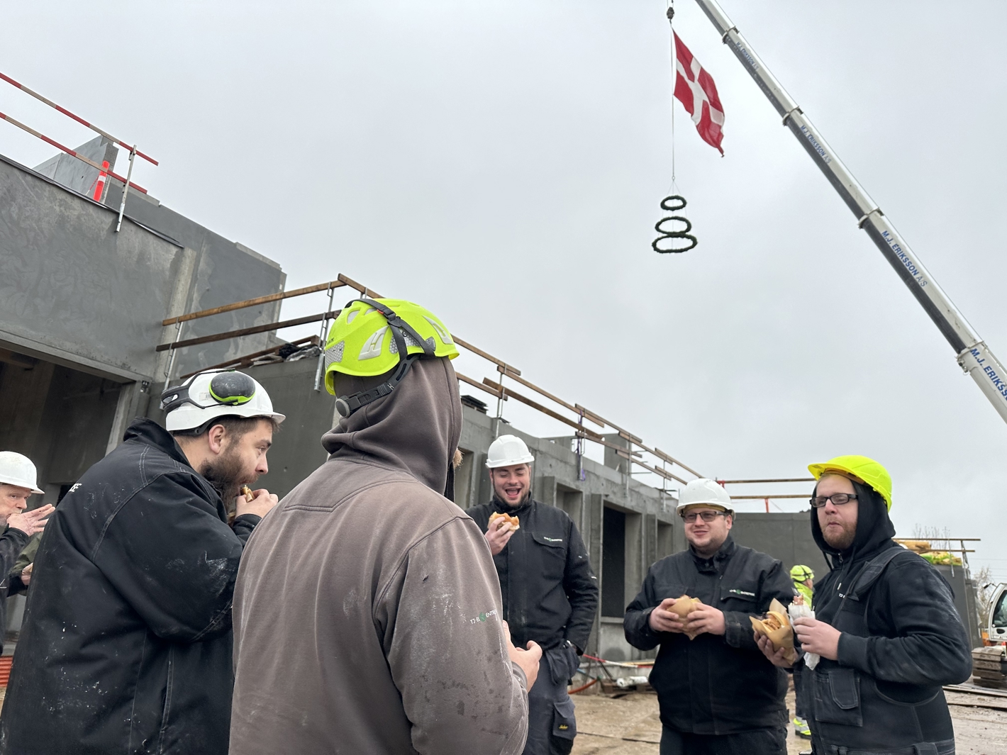 Håndværkere spiser hotdogs og bøfsandwich til rejsegildet for Næstved Svømmehal. 